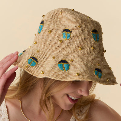 Lele Sadoughi HATS TURQUOISE LAPIS SCARAB EMBELLISHED RAFFIA BUCKET HAT